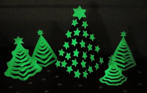 Paper model of Christmas tree glowing in the dark