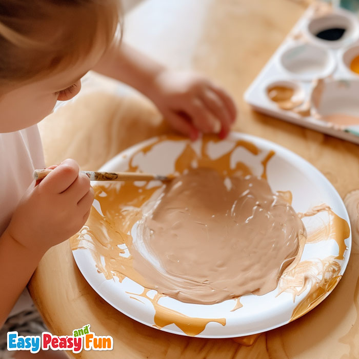 Child painting a paper plate