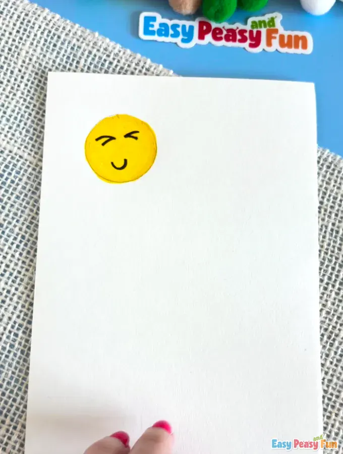 Smiling emoji character with a curved mouth and eyes on the yellow background.