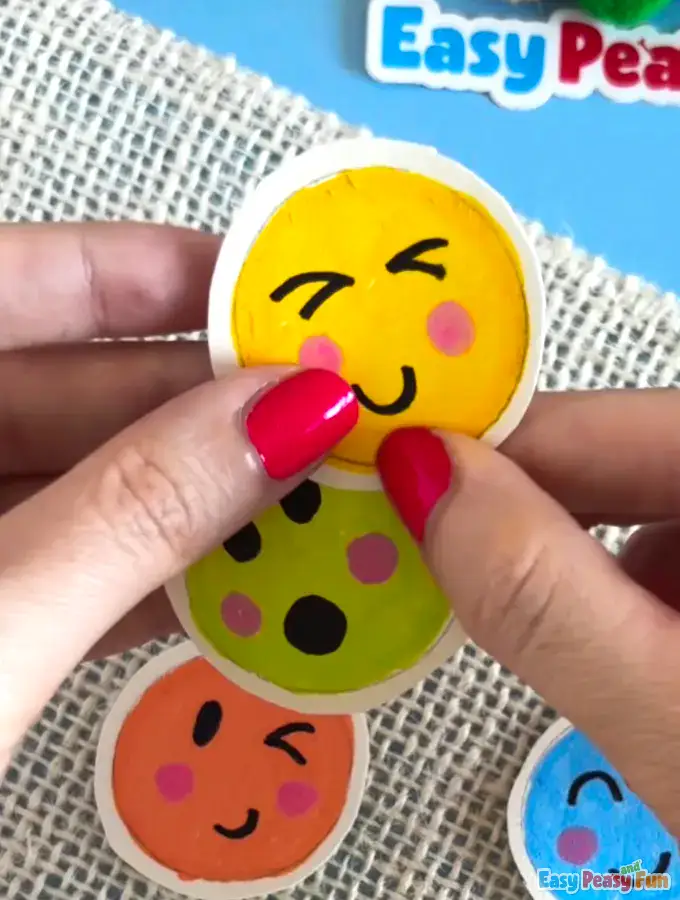 Fingers pressing two emoji circles together to secure the bond.