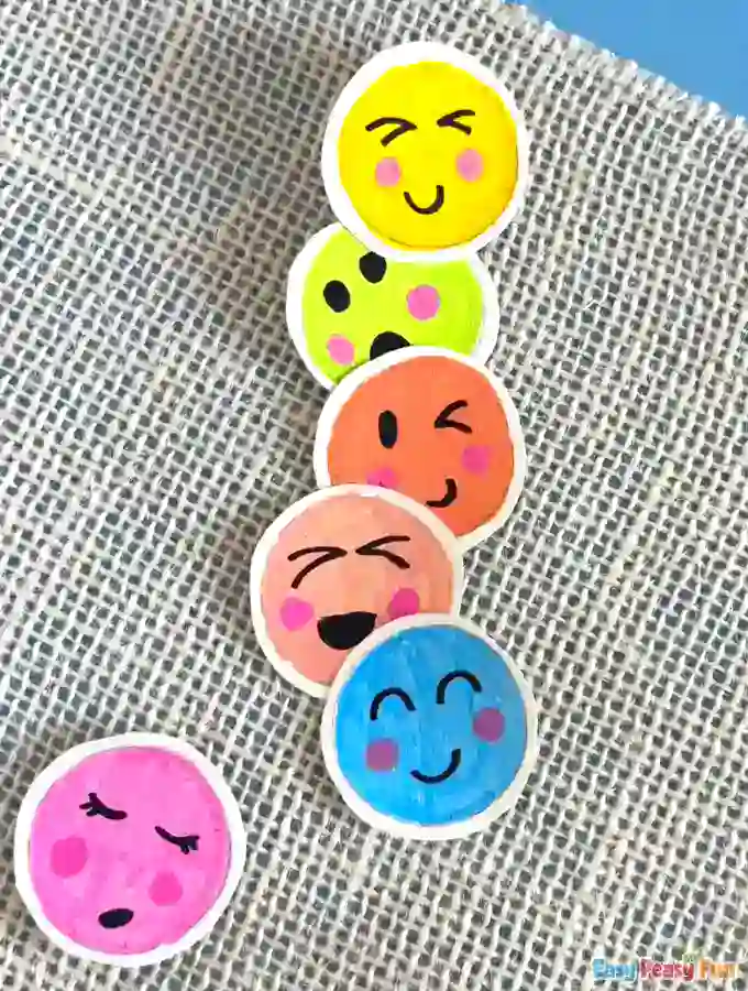 Partially assembled stack of emoji faces on a flat surface.