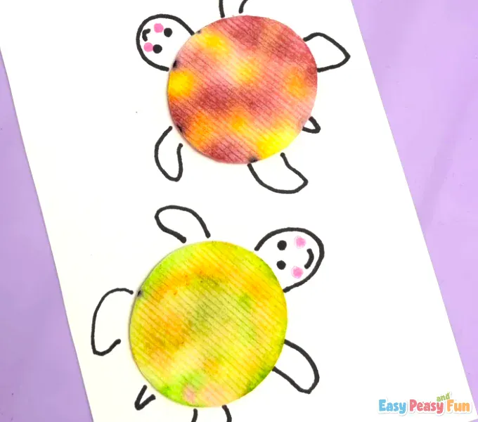 Two finished cotton pad turtles are displayed on the white cardstock, with the second one showing a different color pattern.