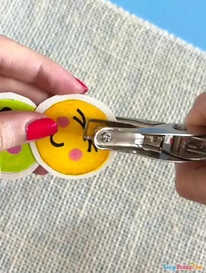 Hole punch being used on the top edge of the emoji circle.