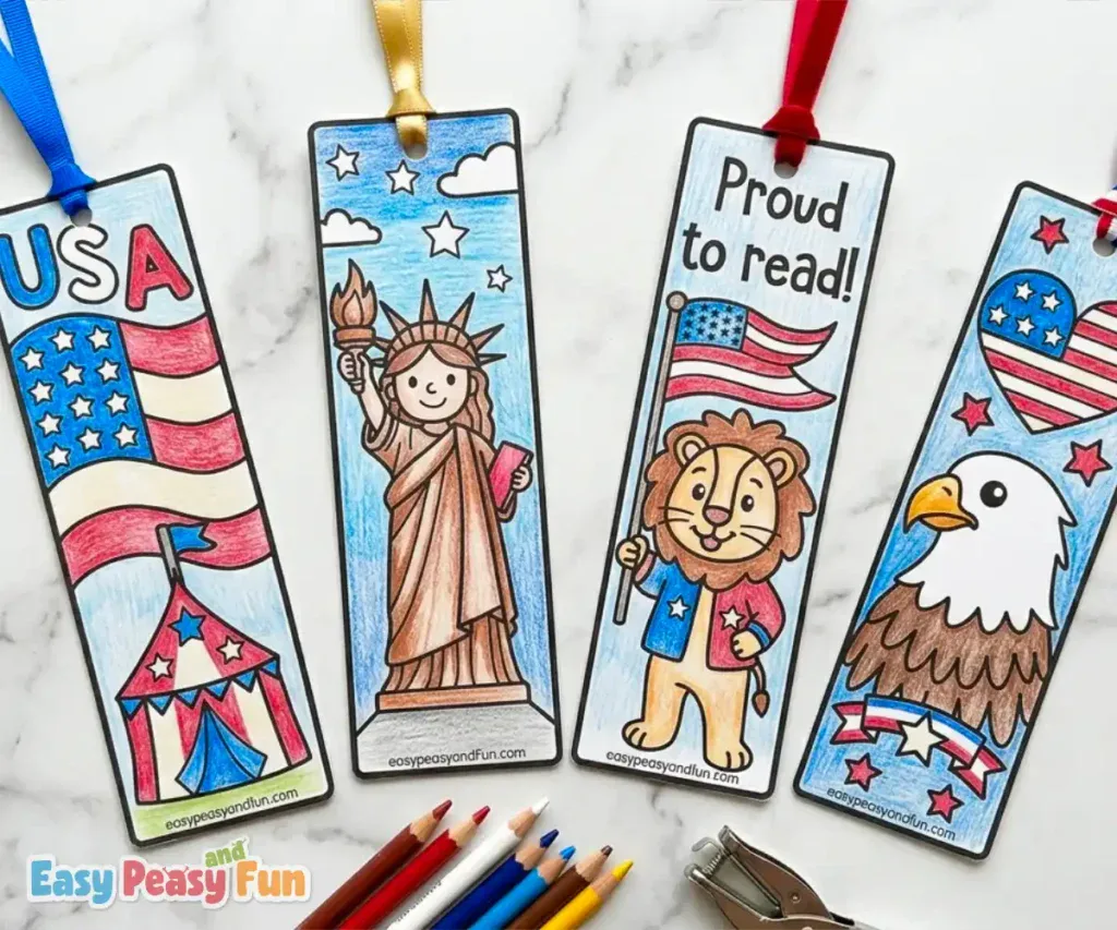 Four completed, hand-colored patriotic bookmarks featuring a circus tent below an American flag, the Statue of Liberty, a lion holding a flag, and a bald eagle.