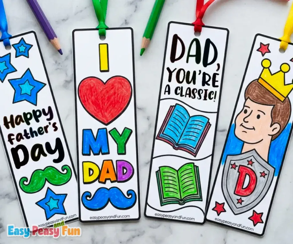 Four colored Father's Day bookmarks with ribbons featuring a Happy Father's Day mustache design, "I Love My Dad" with a big heart, open books "Dad You're A Classic", and a crown wearing Dad with a shield.