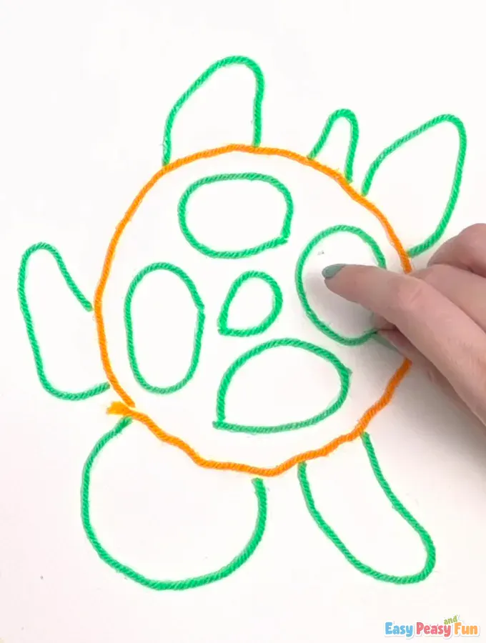 A paintbrush fills the shell segments with yellow paint.