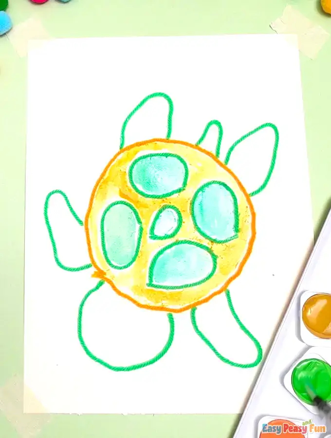 A brush applies green paint to the turtle's limbs.