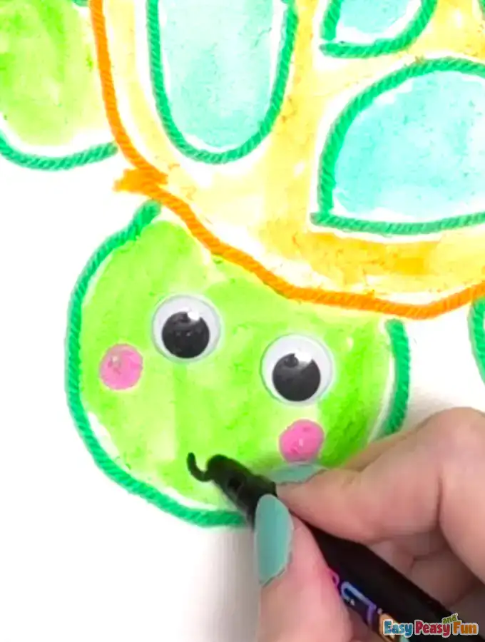 Black marker adds a small, curved smile to the face.