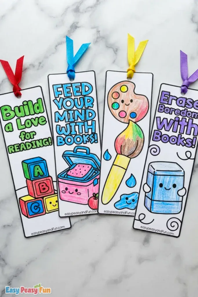 Four vibrant paper bookmarks displaying alphabet blocks, a lunchbox, an artist palette, and a blue eraser.