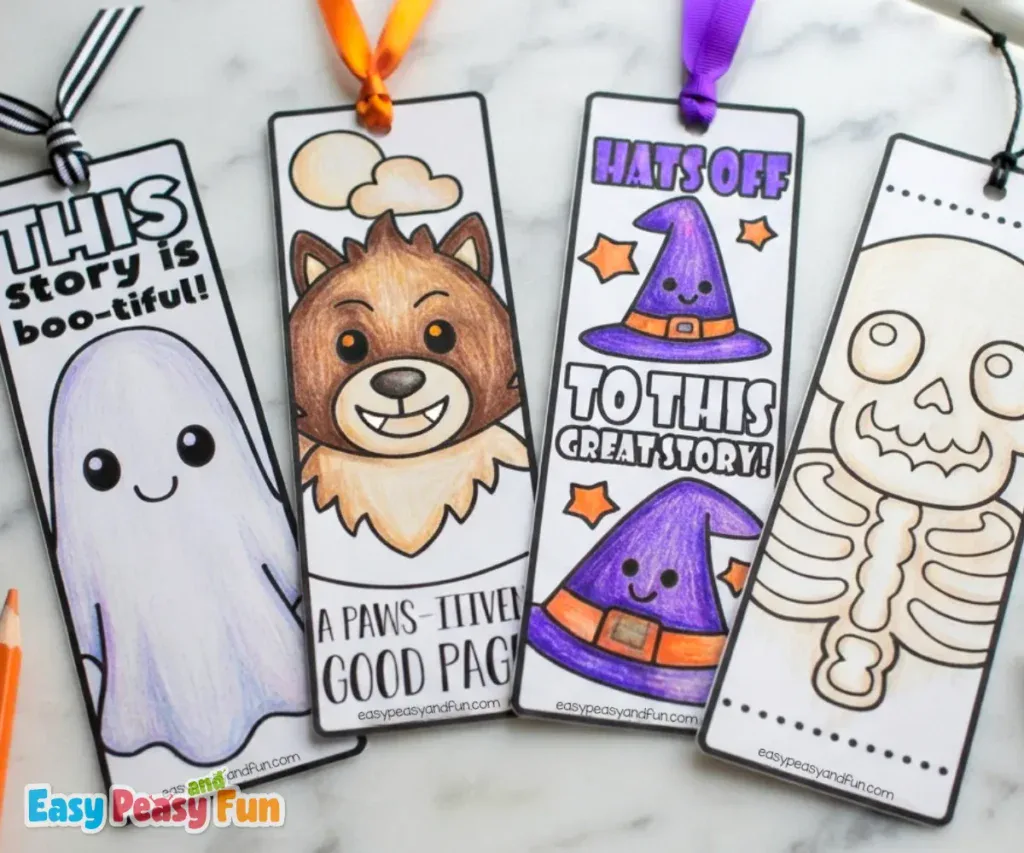 Four colored Halloween bookmarks arranged side-by-side on a marble surface, featuring a ghost, a werewolf, witch hats, and a skeleton.