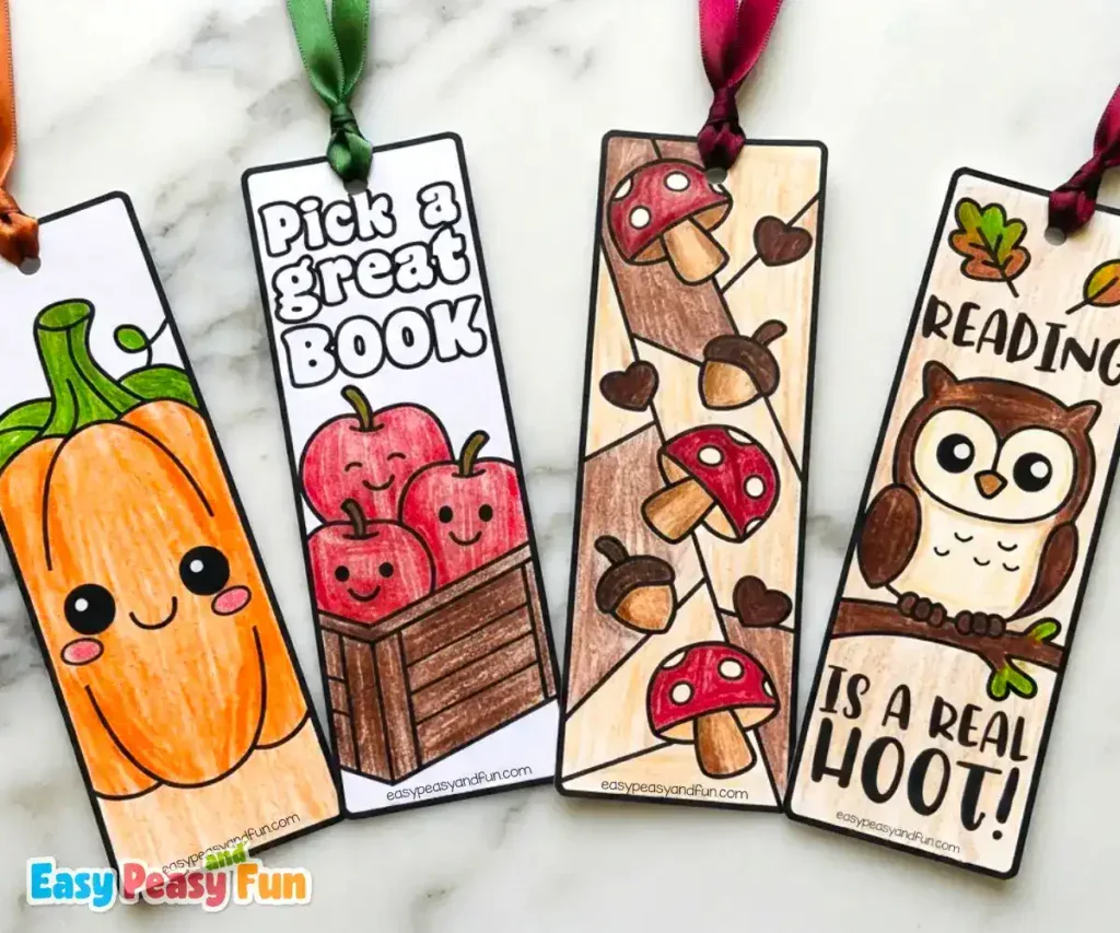 Four colored bookmarks showing a smiling pumpkin, apples in a crate, mushrooms on a branch, and an owl.