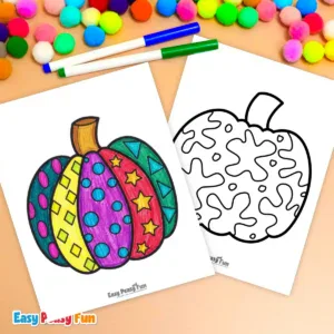 A colored pumpkin sheet next to a blank one, surrounded by markers and pom-poms.