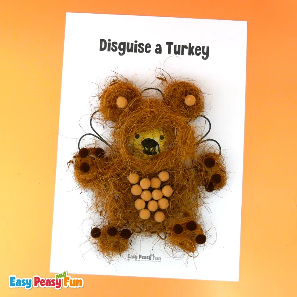 A turkey disguised as a teddy bear made using brown coconut coir fiber for the fur, pom-poms for the belly and paws, and paper ears.