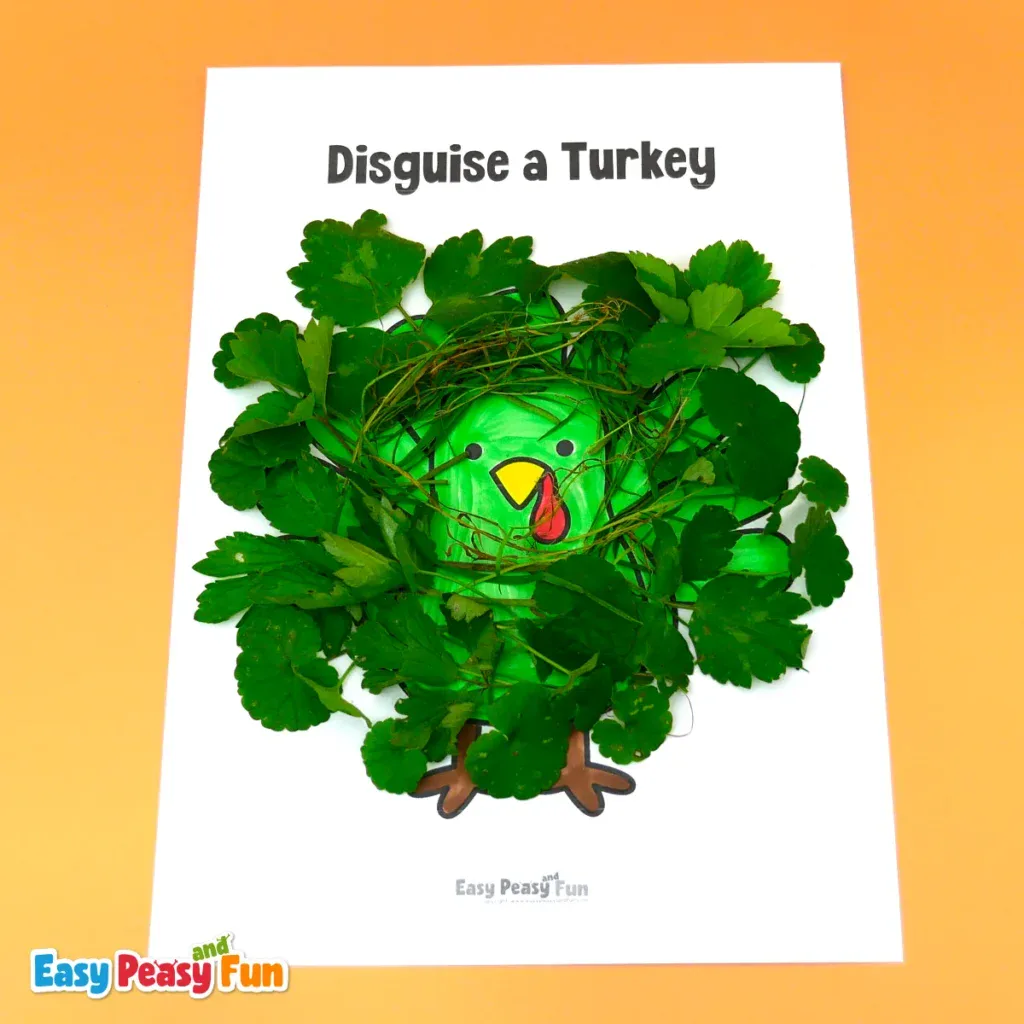 A bright green paper turkey craft disguised as a bush, surrounded by fresh green leaves and fine dried grass around its face.