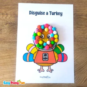 A paper turkey craft template disguised as a gumball machine featuring colorful pom-poms arranged inside a glass dome over an orange base.