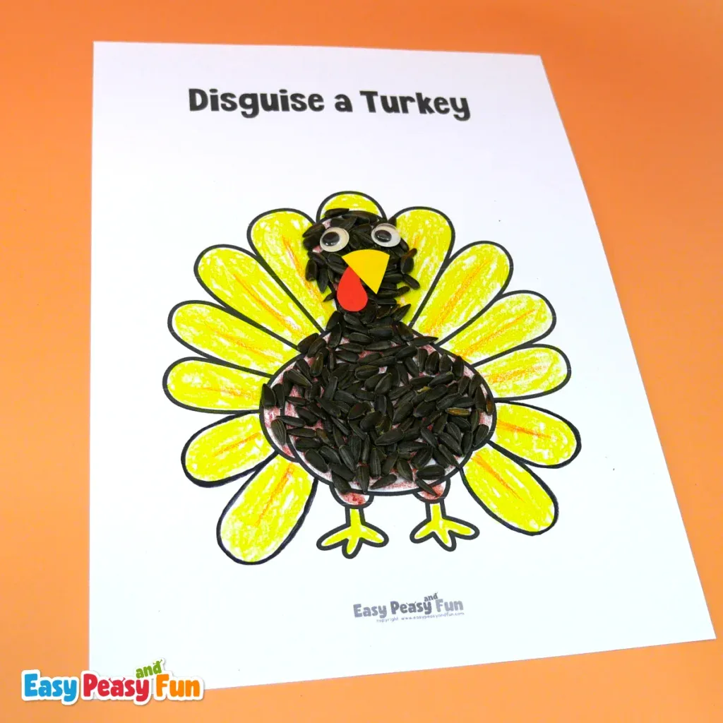 A paper turkey craft with its head and body covered in black sunflower seeds, surrounded by bright yellow painted feather outlines.