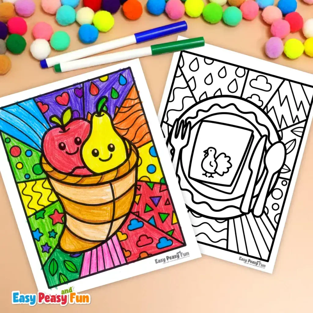 A colored cornucopia page and an uncolored dinner plate page displayed on a table with colorful pom-poms and markers.